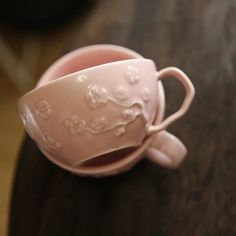 a pink cup sitting on top of a wooden table