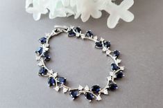 "This glamorous bracelet is loaded with sparkly oval sapphire blue stones, and clear round shaped stones set in a silver plated. setting.  The bracelet would be a perfect accessory for your something blue!  I can design the bracelet with a box clasp and no extender or with an extender. Choose your style at checkout. The bracelet without the extender is 6 1/2\" . The bracelet with the extender will measure 7 1/2\"  including the extender. PACKING:  The bracelet will arrive in a beautiful bow tied gift box. MATCHING EARRINGS https://www.etsy.com/shop/Uniquebeadables?ref=seller-platform-mcnav&search_query=sapphire+earrings ** To view more items in my shop, please click below ** http://www.etsy.com/shop/Uniquebeadables Don't forget to \"LIKE\" Uniquebeadables on FACEBOOK to make sure that you Elegant Sapphire Crystal Bracelets, Blue Crystal Bracelets For Formal Occasions, Blue Crystal Bracelet For Formal Occasions, Elegant Blue Bracelets With Sparkling Stones, Blue Round Crystal Bracelet For Formal Occasions, Blue Sparkling Stones Bracelet For Formal Occasions, Elegant Blue Crystal Bracelet With Sparkling Stones, Blue Crystal Bracelets For Anniversary, Blue Cubic Zirconia Bracelet With Sparkling Stones