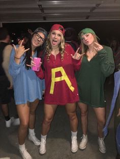 three young women posing for the camera with one holding up her hand and two pointing fingers