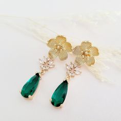 Gold Emerald Green Earrings for brides, weddings and bridal showers. The perfect gift earrings for bridesmaids, mother of the groom, or mother of the bride. Find earrings for bridal bachelorette party or other special occasions here. A gentle cascade of gold flowers and  shimmering Emerald Green crystals in these beautiful nature-inspired bridal earrings. Adding just a hint of sparkle, this pretty pair make gorgeous earrings for both brides and bridesmaids.  Emerald Green glass crystals add a fu Green Flower Shaped Jewelry For Wedding, Green Flower Shaped Wedding Jewelry, Green Flower-shaped Wedding Jewelry, Gold Flower Cluster Earrings For Wedding, Elegant Flower Teardrop Earrings For Gift, Elegant Flower Shaped Teardrop Earrings, Gold Flower-shaped Cluster Earrings For Wedding, Green Dangle Clip-on Earrings For Wedding, Matching Flower Earrings For Bridesmaids Gift