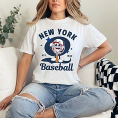 Show off your love for the New York Yankees with our retro style shirt! Crafted with premium materials, this shirt is both comfortable and durable, making it perfect for game days or everyday wear. Whether you're cheering from the stands or watching from home, this shirt is sure to make you stand out as a true fan. Support your favorite team in style with our vintage New York Yankees tshirt today! ⚾ T-shirt: - Comfort Colors - Made with medium pre-shrunk fabric (6.1 oz/yd² (206.8 g/m consisting Casual College Shirt With Sublimation Print, Trendy College Shirt With Graphic Print, Trendy Graphic Print Shirt For College, Retro White T-shirt For Baseball Season, Trendy Baseball Season Graphic Print Tops, Cotton Shirt With Sublimation Print For Baseball Season, Trendy Short Sleeve T-shirt For Baseball Season, Trendy Graphic Print Tops For Baseball Season, Retro College Shirt With Letter Print