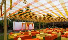 an outdoor wedding setup with orange and yellow linens