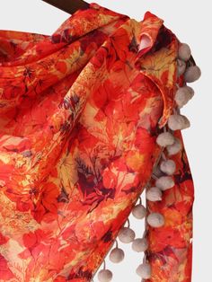 Orange mix leafs digital printed triangular Stole/scarf is crafted in warm pashmina. It is Fenced with Grey Cheese balls pom pom lace. It is a flowy triangular stole. This stole can be draped on your casual outfit a perfect element for your daily use. Color: Orange Fabric: 100% poly pashmina Work Details: Digital printed, embellished with fancy tassel and pom pom lace, big pom pom are tucked on the edges Meausrements: Length - 100 CM Width - 100 CM Hypotenuse - 150 CM Note: The product will be d Big Pom Pom, Pom Pom Lace, Office Wear Dresses, Indian Scarf, Tulip Pants, Hair Accessories Flower, Scarf Hair, Cheese Balls, Stole Scarf