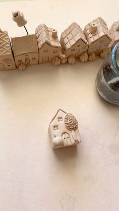 a close up of a small toy house on a table next to a cup and saucer