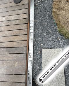 a close up of a metal object on the ground near a wooden fence and grass