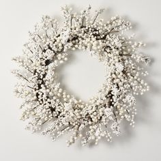 a wreath with white flowers and branches on a white background, top view from above