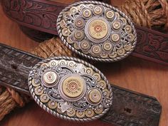 Belt buckles have a rich tradition in cowboy history! They can tell a story, show personality and definitely demonstrate style and this belt buckle does just that! This is the newest in our growing line of designer shotgun & bullet casing belt buckles. This buckle borrows the oval shape of our best selling buckle while incorporating the round center design of our round buckle. The result is another show stopper of a belt buckle! Features a bed of brass 9mm bullet casings embellished with a c Story Show, Cowboy History, Mens Western Style, 9mm Bullet, Fancy Accessories, Mens Western, Bullet Casing, Western Belt Buckles, Cowboy Outfits