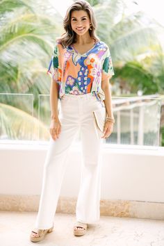 This top is so cute and comfy! That print is so pretty and those colors are so fun. This light blouse is going to look great with white jeans or shorts this spring and summer! V-neckline Short sleeves Floral print No stretch Savannah is wearing the small. Cotton V-neck Top For Spring Day Out, Trendy V-neck Blouse With Vibrant Print, Chic V-neck Top With Bold Print, Casual Short Sleeve V-neck Top For Brunch, Chic Floral Print V-neck Top, Chic White V-neck Top For Day Out, White V-neck Top For Summer Vacation, White V-neck Rayon Top, Summer Cotton V-neck Top For Day Out