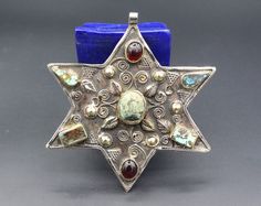 I am offering this vintage Turkmen judaica David star tribal alpaka unique pendant. it is hand made with beautiful Turquoise stones, glass beads and partial gold wash with star shape. Thanks for taking the time to look and please contact for further pictures or info. Measures, Weight : 67.2 grams Length : 10.5cm ( 4.1" ) Width : 10cm ( 3.9" ) Pictures can be slightly light difference, Please know what you are bidding on. The metal of Most Kuchi, Afghan and Turkoman items are called with differen Bohemian Star-shaped Jewelry For Festivals, Bohemian Star Jewelry For Festivals, Bohemian Star-shaped Festival Jewelry, Bohemian Multicolor Star-shaped Jewelry, Vintage Handmade Star-shaped Jewelry, Vintage Handmade Star Jewelry, Bohemian Star-shaped Handmade Jewelry, Handmade Bohemian Star Jewelry, David Star