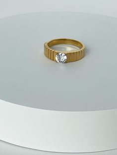 a diamond ring sitting on top of a white surface