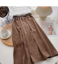 Style: commuting Size: one size Color: coffee, apricot, khaki, black, blue Chic Brown A-line Bottoms, Brown A-line Skirt For Summer, Beige A-line Pleated Skirt For Fall, Casual Brown Solid Color Skirt, Brown Solid Color Long Skirt, Elegant Non-stretch Knee-length Pleated Skirt, Trendy Long Skirt In Solid Color, Brown Solid Color Skirt For Fall, High Waist Solid Beige Skirt