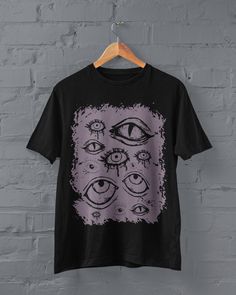 Thanks for stopping by! Grunge Eyes T-shirt Printed on a super soft, cotton tee Dispatched in 5 working days or sooner Unisex Free UK delivery Material: 100% ringspun cotton. Chest (to fit): S  34/36   M  38   L  40/42   XL  44/46   XXL  48/50 ECO-FRIENDLY Each garment is made to order, reducing extra material and energy that would be otherwise wasted We use DTG printing process which is easier on the environment than screen-printing Our ink is bright and also eco-friendly. Do not tumble dry. Wa Emo Black T-shirt With Graphic Design, Fairy Grunge Cotton T-shirt With Graphic Print, Halloween Anime Print Grunge T-shirt, Pink Cotton Emo T-shirt, Pastel Goth Short Sleeve T-shirt For Streetwear, Alternative Funny Print T-shirt For Streetwear, Grunge Purple Top For Streetwear, Punk Halloween Anime Print Top, Halloween Punk Anime Print Tops