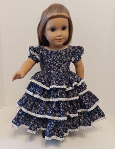 a doll wearing a blue dress with white flowers on it's chest and legs