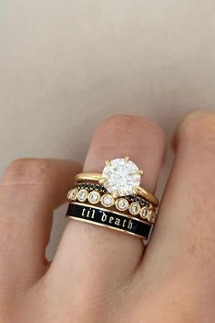 a person's hand with two rings on their fingers and one has a diamond in the middle