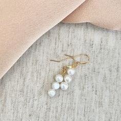 Three small white freshwater pearl & gold plated drop earrings. Beautiful freshwater drop pearl earrings, a very light pearly white in colour, flat & roundish in shape. Please watch the video to see how these beautiful earrings look in more detail. Drop length approx 3cm. The earring hook is gold plated, the wire through the pearls is hypoallergenic metal. As these pearls are natural they will all differ slightly and have natural imperfections. Dainty Pearl Earrings With Pearl Pendant, Dainty Pearl Pendant Earrings, Minimalist Pearl Drop Earrings, Minimalist Pearl Drop Earrings In Pearl White, Pearl White Drop Earrings, Dainty Drop Pearl Earrings, Pearl White Pearl Drop Earrings, White Pearl Chain Bridal Earrings Gift, White Bridal Earrings With Pearl Chain