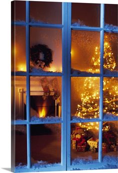 a christmas tree is seen through an open window