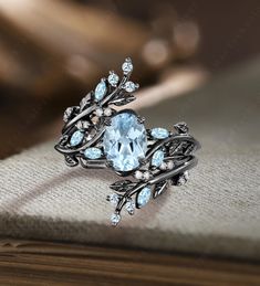 an elegant ring with blue topaz and white diamonds on the side, sitting on a book