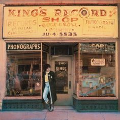 a man is walking in front of a record shop