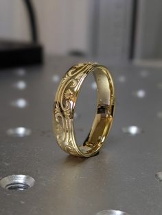 a gold wedding ring sitting on top of a table