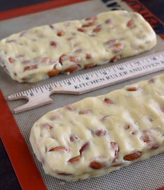 two doughnuts sitting on top of a baking sheet next to a measuring tape