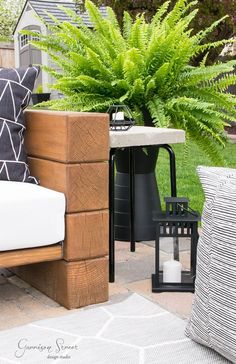 a wooden bench sitting on top of a patio next to a planter filled with flowers