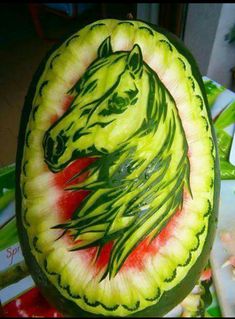 a watermelon carved to look like a horse's head with green manes