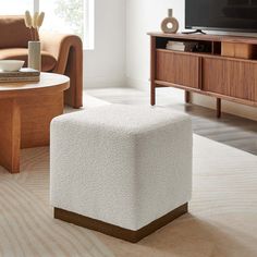 a living room scene with focus on the coffee table and footstool in the foreground