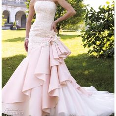 a woman in a pink wedding dress posing for the camera with her hands on her hips