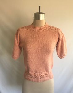 Sweet 1980's (could be newer) does 1940's rose pink hand knit short sleeve pullover sweater! Sweater features a unique vine design across the back, upper front shoulders and around the hem. Yarn used is super soft and is likely a cotton blended with rayon. Sweater is clean and in excellent condition!  There is a small spot on the center of the upper back (see photo).  No label - beautifully hand knitted!  Measurements: would best fit a modern size S Bust= 33" relaxed, 36" stretched  Bottom openi Vintage Crew Neck Knit Top, Vintage Knit Crew Neck Top, Pink Fitted Cottagecore Top, Fitted Pink Cottagecore Top, Pink Vintage Spring Sweater, Vintage Winter Knit Tops, Spring Vintage Pink Sweater, Vintage Pink Spring Sweater, Vintage Pink Sweater For Spring