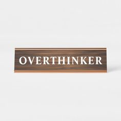 a wooden sign that says overthinker on it