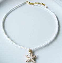 Starfish Choker Sea Choker White Choker Necklace White Beaded Choker Summer Jewelry Beach Necklace Dainty and elegant all white beaded choker with glass tiny seed beads and a white enameled starfish charm. DESCRIPTION Made from 2mm glass seed beads and closes with a gold plated clasp and 2 inches adjustable chain. SIZE Necklace is 13 inches and can be adjusted up to 15 inches with a 2 inches extender chain. Please let me know if you would like a different length. WRAPPING - All ZafireniaDainty j White Star-shaped Ocean-inspired Jewelry, Ocean-inspired White Star Jewelry, Ocean-inspired White Star-shaped Jewelry, Ocean-inspired Starfish Charm Beaded Necklace, White Star-shaped Jewelry With Starfish Charm, White Starfish Beaded Necklaces For Beach, White Starfish Pendant Ocean-inspired Jewelry, White Star Necklace For Beach, Adjustable White Jewelry With Starfish Charm