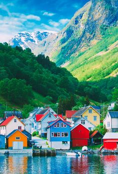 colorful houses on the water with mountains in the background