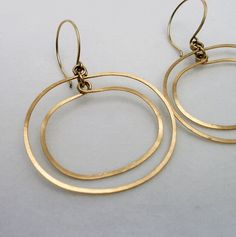 "Gold Oval Double Hoop Earrings ~ A modern retro take on the simple hoop dangle. Beautifully hand crafted of hammered gold fill wire, the two hoops move independently giving a subtle glimmer with every move you make. They are extremely light weight and perfect if you can't wear heavy earrings but like to wear a larger earring.  2\" length including the ear-wire and 1 5/8\" at the widest point. They fall just below the jawbone. Your purchase will arrive beautifully packaged in a floral jewelry bo Hammered Wire Jewelry, Kinetic Jewelry, Mod Jewelry, Heavy Earrings, Metalsmithing Jewelry, Earrings Geometric, Hammered Gold, Work Jewelry, Large Earrings