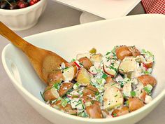 a white bowl filled with potatoes and salad