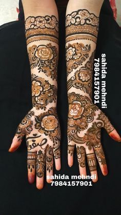 two hands with henna tattoos on them, one is showing off the intricate design