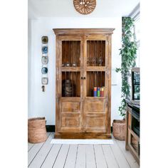 a large wooden cabinet sitting inside of a living room next to a wall mounted clock