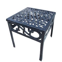 an iron side table with intricate designs on the top and bottom, against a white background