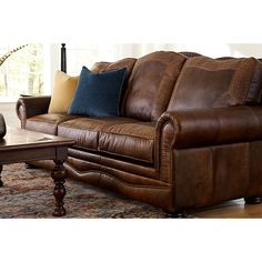 a brown leather couch sitting on top of a wooden table