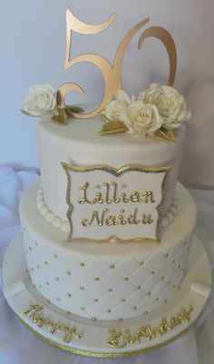 a white and gold 50th birthday cake with roses