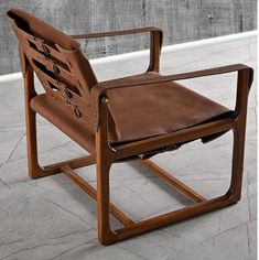 a brown leather chair sitting on top of a cement floor