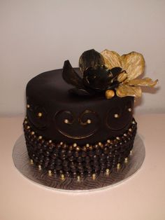 there is a chocolate cake with gold decorations on it