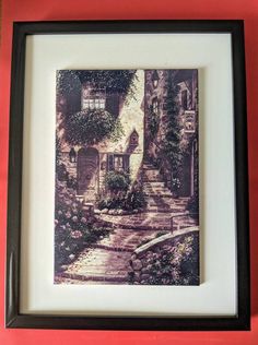 a framed photo of a house with steps and flowers