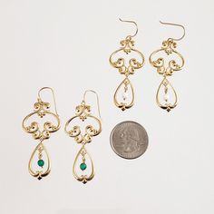 Step back in time with these elegant vintage style drop earrings. The intricate scrollwork design in 18K yellow gold plated bronze brings a touch of old-world glamour to your look, while the 4mm round faceted gemstone beads in your choice of green agate or white agate add a subtle pop of color. These earrings are the perfect finishing touch to any outfit, whether you're dressing up or down. Elevate your style with these beautiful and timeless earrings. Vintage Style Drop Earrings Scrollwork 4mm Vintage Gold Earrings For May Birthstone, Elegant Green Earrings With Intricate Design, Elegant Green Chandelier Earrings With Intricate Design, Elegant Antique Gold Nickel-free Earrings, Elegant Antique Gold Drop Earrings, Elegant Brass Chandelier Earrings For Formal Occasions, Elegant Antique Gold Jewelry, Elegant Filigree Earrings In Antique Gold, Elegant Gold-plated Chandelier Earrings With Intricate Design