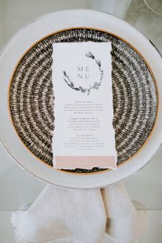 a white plate topped with a menu on top of a table