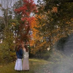 two women are standing in the woods with their backs to each other