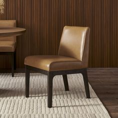 a brown chair sitting on top of a white rug next to a wooden dining table