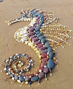 a seahorse made out of rocks on the beach