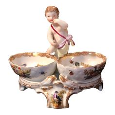 a figurine sitting on top of two bowls