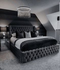 a large bed sitting under a chandelier in a bedroom