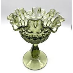 a green glass bowl sitting on top of a table